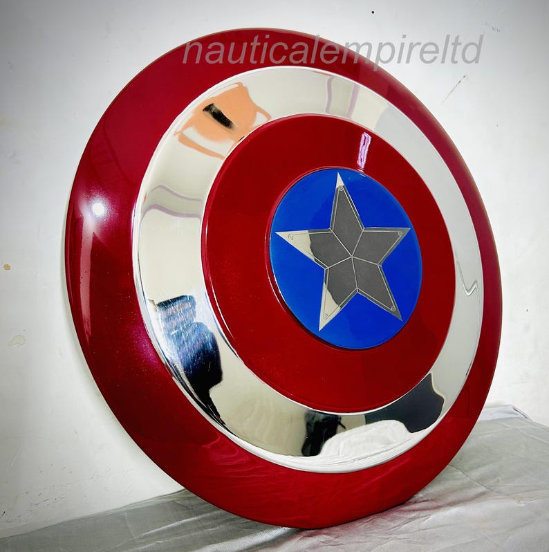 May include: A red, white and blue Captain America shield with a silver metal rim. The shield has a five-pointed star in the centre.