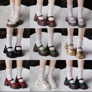 May include: A collection of nine pairs of doll shoes in various colours including white, brown, grey, black, green, gold, red, and silver. Each pair features a Mary Jane style with a strap, a thick platform sole, and is worn with white socks.