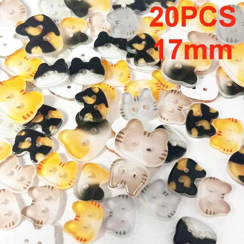 May include: A collection of cat-shaped buttons in various colors, including yellow, black, and clear. The buttons are approximately 0.67 inches in diameter and have two holes for sewing. The image includes the text "20PCS 17mm".
