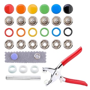 Puede incluir: Un conjunto de broches de presión de colores en rojo, naranja, amarillo, verde, azul y negro. El juego incluye componentes de broches de presión de metal plateado, anillos de colores, una tira de fieltro gris con un broche y una herramienta de broche de presión con mango rojo.