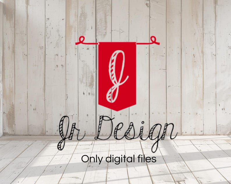 Może przedstawiać: Czerwona wstążka z białą literą "J" w środku wisi na białym drewnianym tle. Pod wstążką widnieje napis "Jr Design" i "Only digital files".