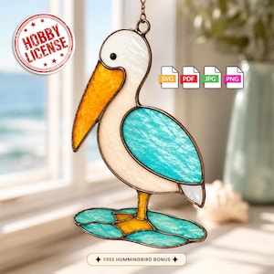 May include: A stained glass pelican suncatcher featuring a white body, a textured orange beak, and turquoise wings. The bird stands on a turquoise and orange base. The image includes text reading HOBBY LICENSE, SVG, PDF, JPG, PNG, and FREE HUMMINGBIRD BONUS.