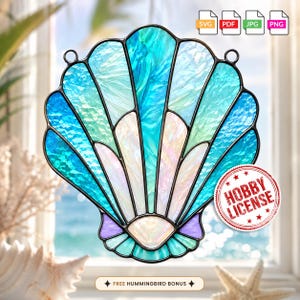 May include: A stained glass seashell suncatcher featuring iridescent blue, teal, and white glass panels held together by black metal cames. The design includes two top hanging loops and a circular red stamp that reads HOBBY LICENSE.