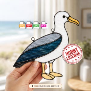 May include: A stained glass seagull suncatcher featuring white, dark blue, and yellow glass pieces with black metal solder lines. The design includes small metal loops for hanging and text icons for SVG, PDF, JPG, PNG, and a Hobby License stamp.