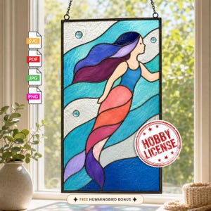 May include: A rectangular stained glass panel featuring a mermaid with long flowing purple and blue hair, a blue top, and a multi-colored tail in shades of red, pink, and purple, set against a background of wavy light blue and white glass.