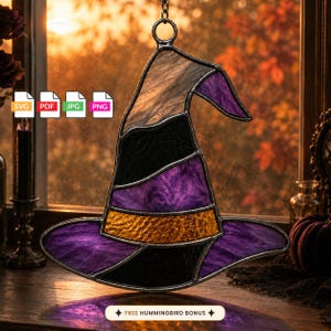 May include: A stained glass witch hat suncatcher featuring a pointed top, a wide brim, and a central band. The hat is constructed from textured glass panels in shades of purple, black, and orange, held together by dark metal solder lines.