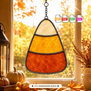 May include: A stained glass suncatcher shaped like a candy corn with white, orange, and yellow sections, framed in dark metal with a hanging chain. The design features text icons for SVG, PDF, JPG, and PNG files and a bonus hummingbird label.