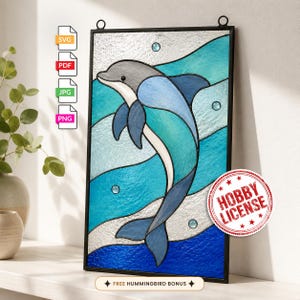 May include: A rectangular stained glass panel featuring a gray and blue dolphin swimming through wavy bands of light blue, turquoise, and dark blue glass. The design includes small circular accents and a red circular stamp reading HOBBY LICENSE.