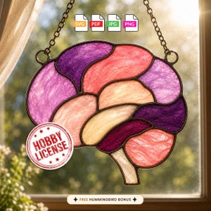 May include: A stained glass brain suncatcher featuring segments in shades of purple, pink, and peach, outlined in dark metal. The piece hangs from a metal chain and includes icons for SVG, PDF, JPG, and PNG files, a Hobby License stamp, and text.