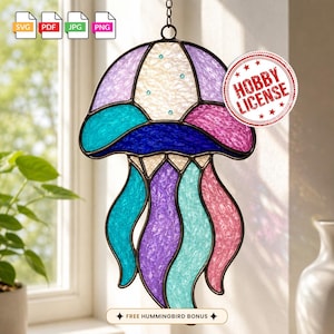 May include: A stained glass jellyfish suncatcher featuring a textured white bell with small blue accents, a dark blue horizontal band, and flowing tentacles in shades of purple, teal, and pink. Includes SVG, PDF, JPG, and PNG file icons.