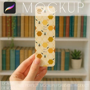 Può includere: Un segnalibro rettangolare con un motivo a nido d'ape, api e la scritta "Buzzy Mama". Il segnalibro ha uno sfondo beige con forme esagonali marroni e gialle. Il design include piccole api e corone.
