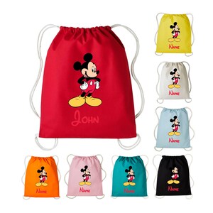 May include: A set of ten drawstring bags featuring a cartoon image of Mickey Mouse. The bags are available in a variety of colours, including red, yellow, white, blue, orange, pink, turquoise, and black. The bags have a white drawstring and are personalised with the name "John" on the red bag.