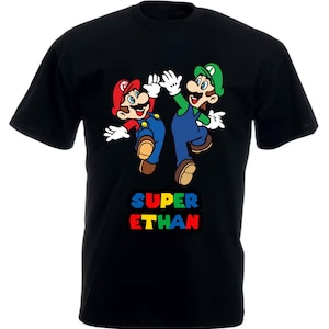 May include: Black t-shirt featuring a graphic of Mario and Luigi characters from the Super Mario Bros. video game. The text "SUPER ETHAN" is printed below the characters in rainbow colours.