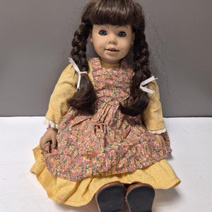 Heidi Ott-docka Hannah. Mäter cirka 50 cm lång. Brunt hår och blå ögon. 2 gropar. Visar 2 tänder. Originalkläder och skor.