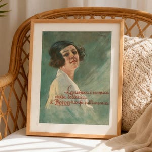 May include: A framed vintage-style print featuring a portrait of a person with dark hair wearing a white garment against a teal background. The text reads: L'anemia è nemica della bellezza, il Proton trionfa sull'anemia in red cursive script.