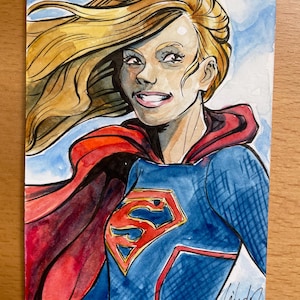 Carte à croquis aquarelle Leila del Duca représentant Supergirl. Livraison gratuite aux États-Unis !