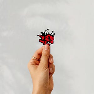 Holding a sticker of cardiff devils ice hockey team logo on a white background