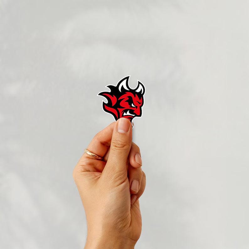 Holding a sticker of cardiff devils ice hockey team logo on a white background