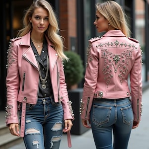 May include: Two women wearing pink leather jackets with silver embellishments. The jackets have a zipper closure and a belt at the waist. The women are wearing blue jeans.