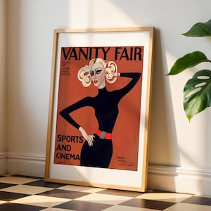 Op de afbeelding: Een vintage-stijl Vanity Fair magazinecover met een vrouw met blond haar die een zwarte turtleneck en een rode riem draagt. De tekst op de cover luidt "Sport en Cinema".