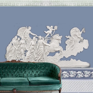 Op de afbeelding: Een witte gipsen reliëfsculptuur die een wagen voorstelt die door een paard wordt getrokken met een groep figuren in vloeiende gewaden. De sculptuur is gemonteerd op een blauwe muur met een decoratieve rand boven en onder.