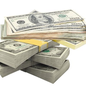 Puede incluir: Varias pilas de billetes de cien dólares estadounidenses. La imagen muestra la moneda, con algunas pilas atadas con bandas amarillas. El retrato de Benjamin Franklin y el número 100 son visibles en los billetes.