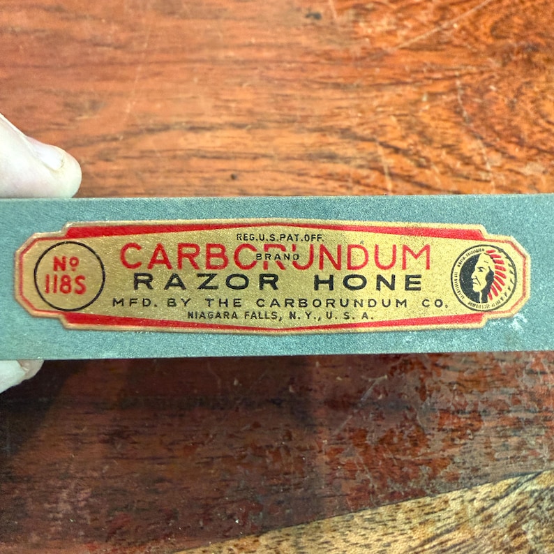 May include: A vintage Carborundum Razor Hone, with a red and gold label. The label includes the text "CARBORUNDUM BRAND RAZOR HONE" and "MFD. BY THE CARBORUNDUM CO. NIAGARA FALLS, N.Y., U.S.A."