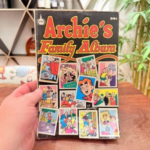 Könnte beinhalten: Ein alter Archie's Family Album Comic mit schwarzem Einband und dem Titel in gelber und roter Schrift. Das Cover zeigt zahlreiche kleine, farbenfrohe illustrierte Felder, die verschiedene Szenen mit Charakteren aus der Archie-Serie darstellen.