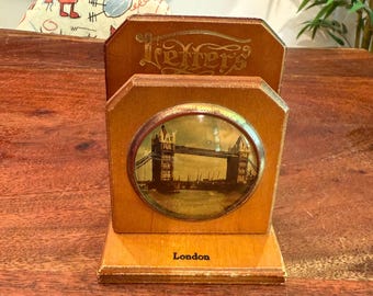 Könnte beinhalten: Briefhalter aus Holz im Vintage-Design. Er zeigt ein ovales Bild der Tower Bridge in London. Das Wort "Letters" ist in goldener Schrift geschrieben. Auf der Basis des Halters steht "London".