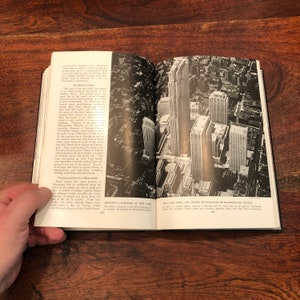 May include: An aerial view of the city skyline with tall buildings, including the Rockefeller Center, in New York City. The text "CITY - THE STEEL AND STONE SKYSCRAPERS OF ROCKEFELLER CENTER" is visible at the bottom of the image.