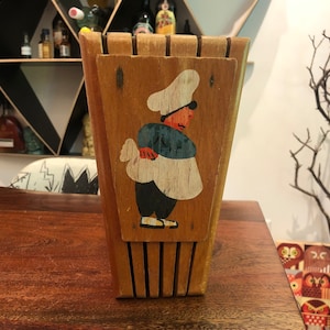 Puede incluir: Portacuchillos de madera con un diseño pintado de un chef que lleva un sombrero blanco y ropa azul y blanca.