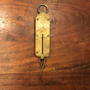 May include: A vintage brass hanging scale with a white dial and the text "CHAS. W. BROWN & CO. NEW YORK, U.S.A. NOT LEGAL FOR USE IN TRADE".