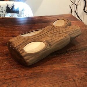 Peut inclure: Une jardinière en céramique marron en forme de bûche évidée avec un extérieur texturé imitant l'écorce. La jardinière présente deux ouvertures ovales distinctes sur le dessus, révélant chacune un bassin intérieur blanc cassé.
