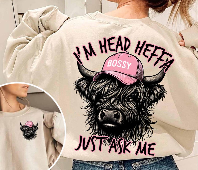 May include: A cream colored sweatshirt with a black and white illustration of a Highland cow wearing a pink hat that says "Bossy". The text "I'm Head Heffa Just Ask Me" is printed in pink on the sweatshirt.