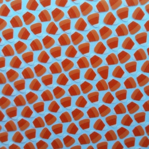 May include: A sheet of orange and white candy corn stickers. The stickers are arranged in a repeating pattern.