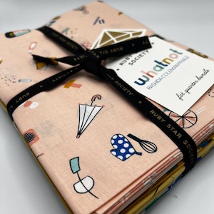 May include: A bundle of fat quarters tied with a black ribbon. The fabric has a light peach background with various illustrated objects in white, blue, and black. The tag reads "whatnot" and "fat quarter bundle".