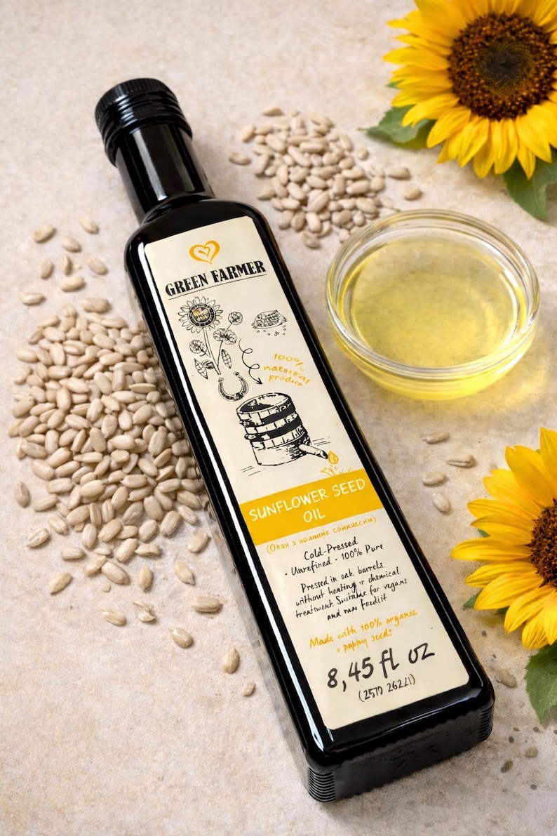 K&ouml;nnte beinhalten: Eine schwarze Flasche Sonnenblumenkern&ouml;l mit einem Etikett mit einer Sonnenblumenillustration und dem Text "Green Farmer". Die Flasche ist umgeben von Sonnenblumenkernen, einer kleinen Sch&uuml;ssel &Ouml;l und Sonnenblumen. Die Flasche enth&auml;lt 250 ml.