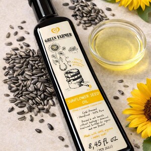 K&ouml;nnte beinhalten: Eine schwarze Flasche Green Farmer Sonnenblumen&ouml;l mit einem Etikett mit einer Sonnenblumenillustration. Das Bild enth&auml;lt Sonnenblumenkerne, eine kleine Sch&uuml;ssel &Ouml;l und eine Sonnenblume. Die Flasche enth&auml;lt 250 ml.