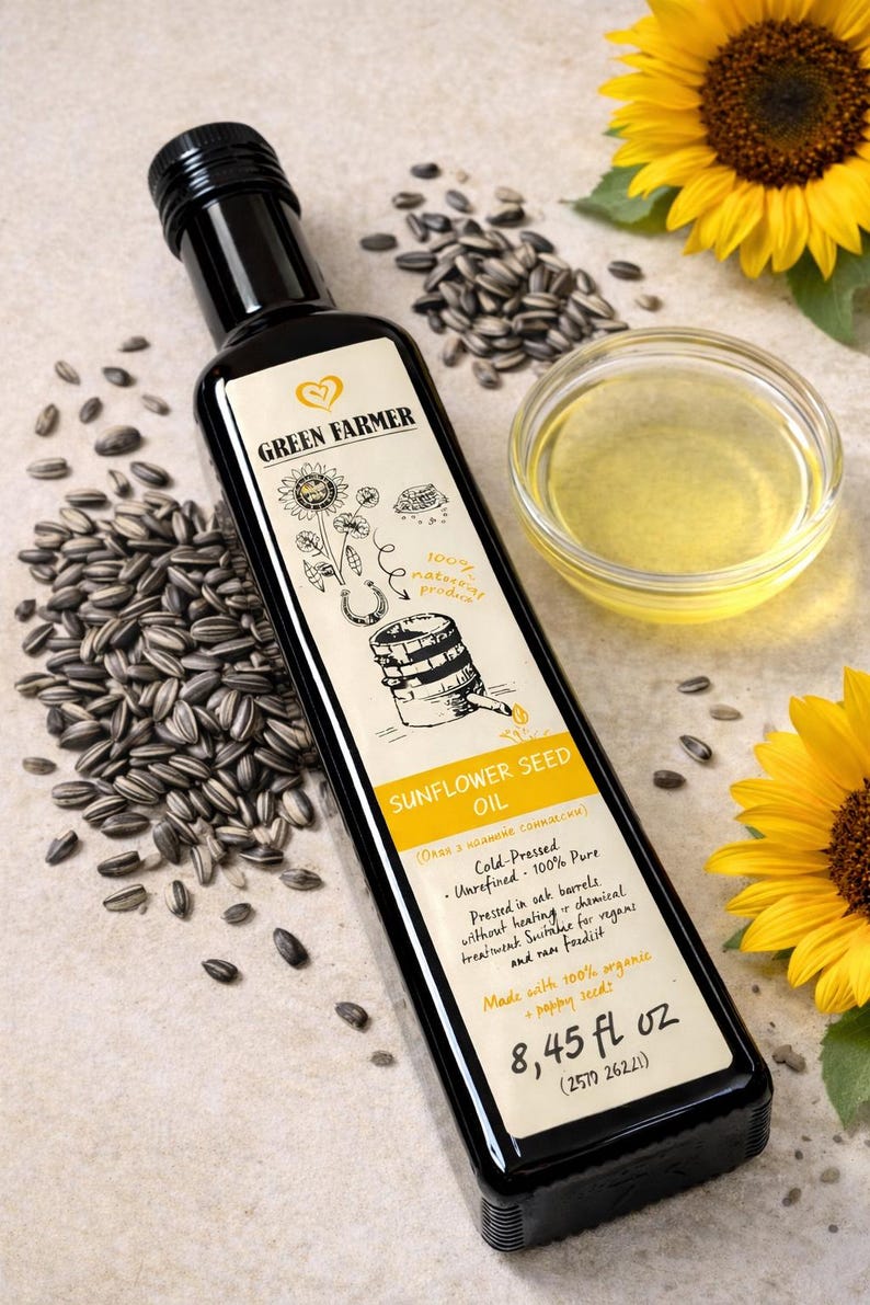 K&ouml;nnte beinhalten: Eine schwarze Flasche Green Farmer Sonnenblumen&ouml;l mit einem Etikett mit einer Sonnenblumenillustration. Das Bild enth&auml;lt Sonnenblumenkerne, eine kleine Sch&uuml;ssel &Ouml;l und eine Sonnenblume. Die Flasche enth&auml;lt 250 ml.