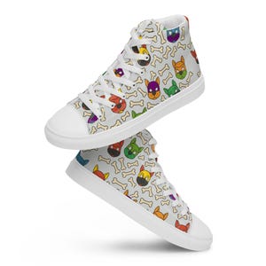 May include: High-top canvas sneakers with a repeating pattern of colorful dog faces and bones on a light gray background. The shoes have white laces, a white rubber sole, and a white toe cap. The design features various dog breeds in shades of red, yellow, green, purple, and blue.