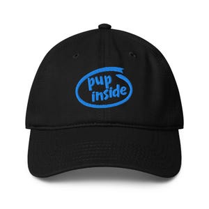 May include: Black baseball cap with a curved brim. The cap features the text "pup inside" in blue, inside a blue oval design. The cap is made of a soft material and has a structured fit.