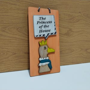 Może przedstawiać: Ręcznie robiony drewniany znak z napisem "Welcome" w zabawnym kroju pisma. Znak ma postarzone białe tło i ciemnobrązową ramę, idealny do drzwi wejściowych. Znak ma około 30 cm szerokości i 15 cm wysokości.