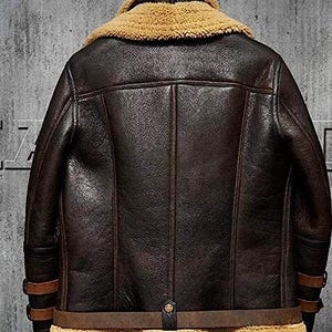 May include: A dark brown leather jacket with a tan shearling collar and lining. The jacket features a classic design with a belted waist, buckle details on the sleeves, and a button closure. The jacket is a medium weight and appears to be well-constructed.
