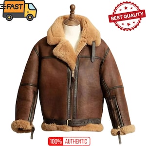 Pode incluir: Casaco de couro castanho com gola e forro de pele de carneiro bege. O casaco apresenta fecho de correr, cinto na cintura e o texto "100% AUTHENTIC". O casaco é exibido num manequim.