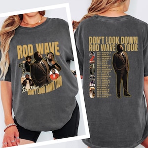 May include: A charcoal gray t-shirt featuring Rod Wave graphics. The front displays multiple images of the artist and the text Rod Wave Don't Look Down Tour. The back shows a full-length image of the artist, the text Don't Look Down Rod Wave Tour, and a list of tour dates for 2026.