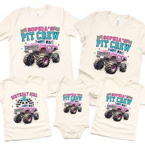 May include: Cream-colored t-shirts and a onesie featuring a monster truck design. The shirts display the text "SOPHIA'S PIT CREW" and "BIRTHDAY GIRL 8". The monster truck is pink with black tires and a checkered flag.