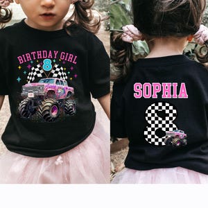 May include: Black t-shirt with a colorful graphic featuring a monster truck with a unicorn design, checkered flags, and the text "BIRTHDAY GIRL 8". The back of the shirt displays the name "SOPHIA" and a checkered number 8.