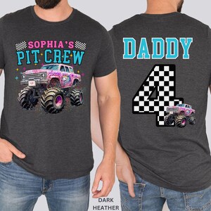 May include: Dark heather gray t-shirt with a monster truck graphic. The front of the shirt says "Sophia's Pit Crew" above a pink monster truck with a unicorn design. The back says "Daddy" above a checkered number 4.