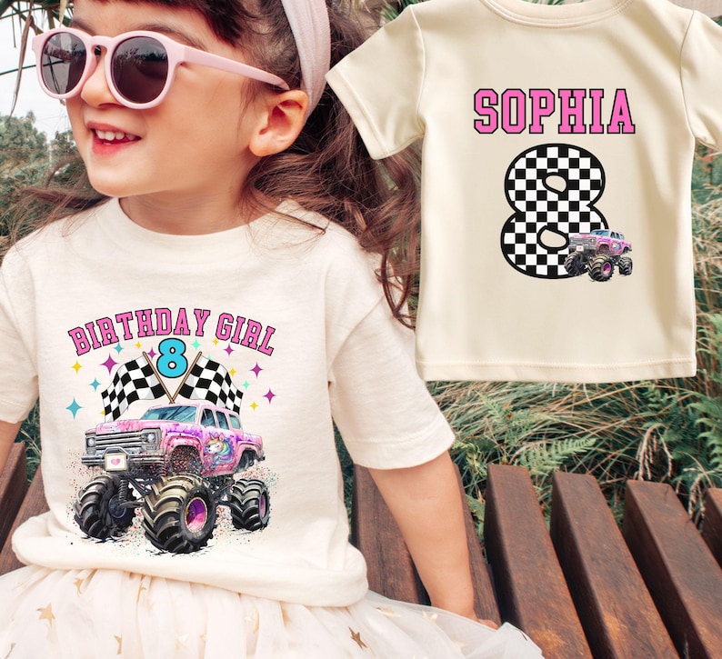Girl model is wearing a personalized unisex t-shirt in Natural with a pink and purple monster truck with a unicorn on it, black and white checkered racing flags, stars and confetti and it says " Birthday Girl" in Varsity Pink letters and number 8 in  teal blue. The back of the shirt has name and number jersey style "Sophia" in Pink Varsity letters and a black and white checkered 8 with a small pink truck at the bottom of it. Family Matching t-shirts for the whole family for girls Birthday Party.