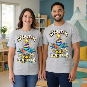 May include: A light gray short-sleeve t-shirt featuring a colorful graphic with the text SPED TEAM TURNING SMALL STEPS INTO BIG BREAKTHROUGHS. The design includes stylized hands, a yellow star, and stacked circular shapes in vibrant colors.